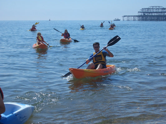 Group of kayakers on Brighton sea with West Pier in background